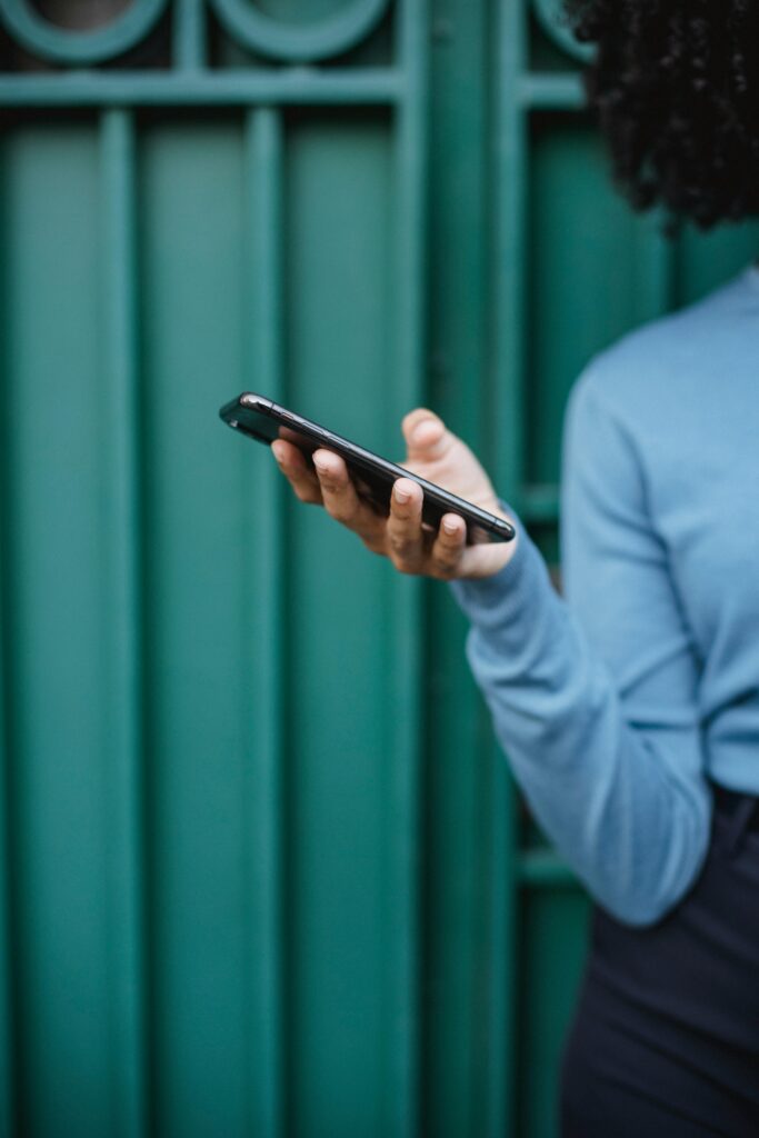Photo of a Person's Hand Holding a Black Cell Phone